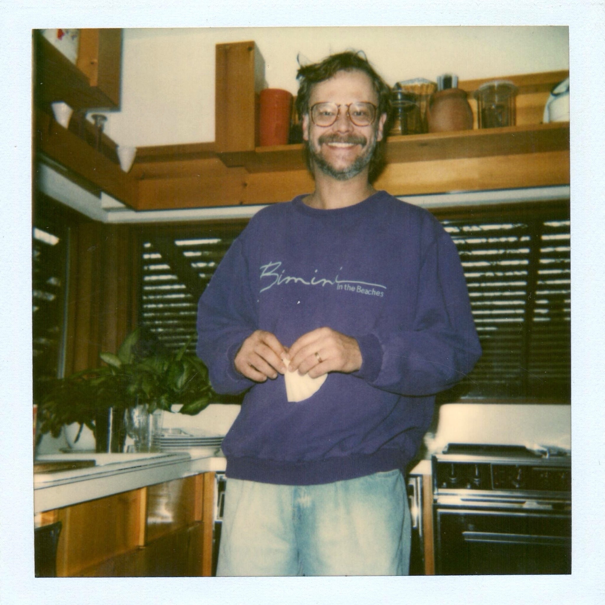 Man in a kitchen wearing a Bimini In The Beaches sweatshirt