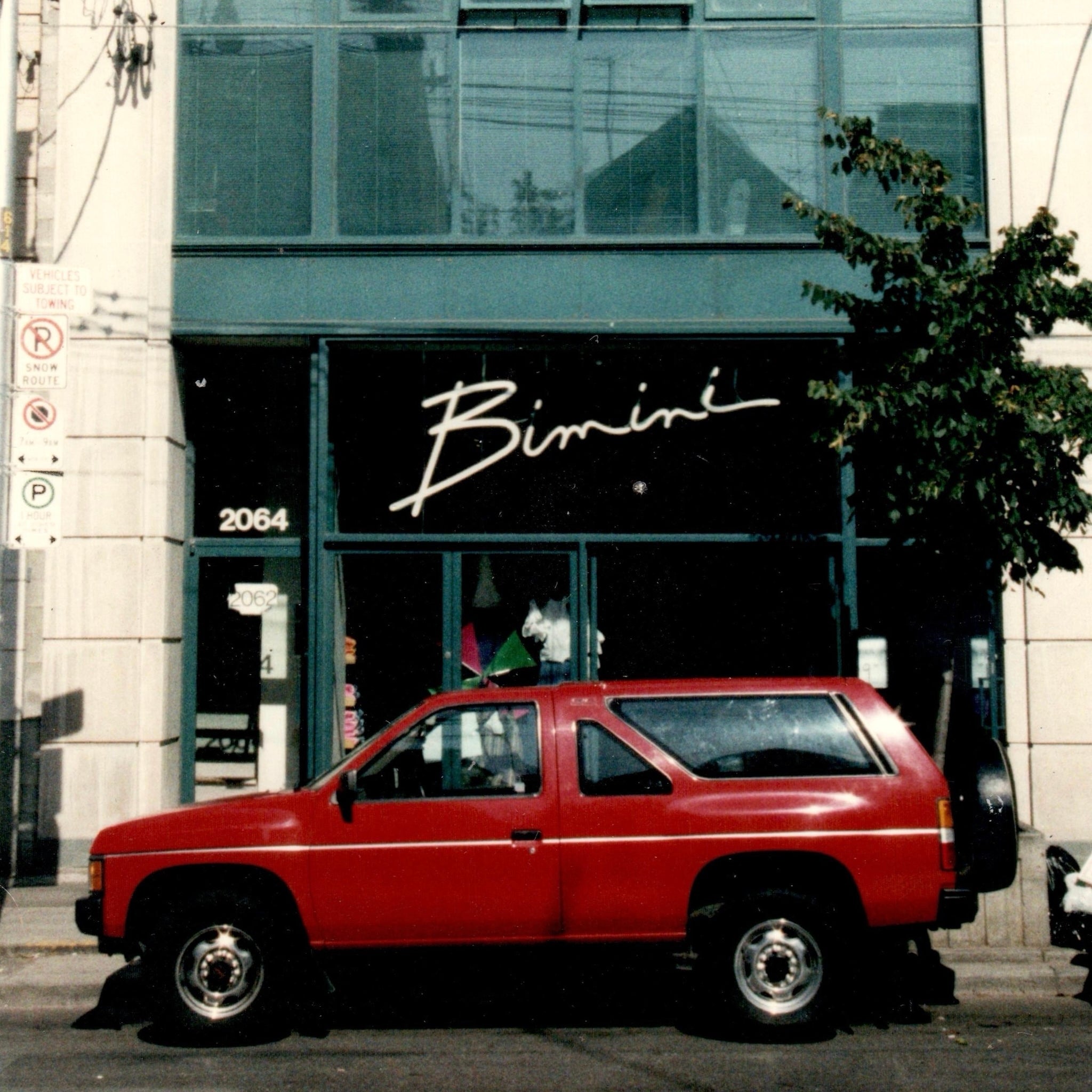 The Bimini storefront with a red car in front.